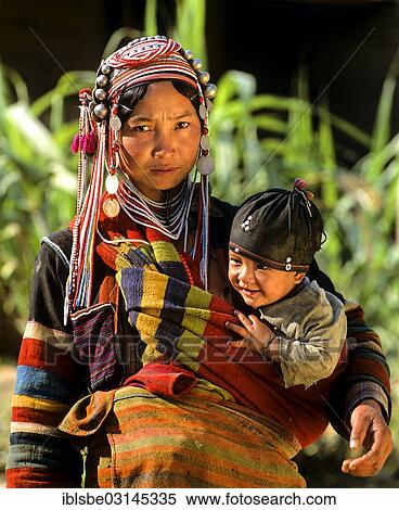 "Young Akha woman carrying a child, in traditional costume and headdress, Chiang Rai Province, Northern Thailand, Thailand, Asia" View Large Photo Image Stock Photography - "Young Akha woman carrying a child, in traditional costume and headdress, Chiang Rai Province, Northern Thailand, Thailand, Asia". Fotosearch