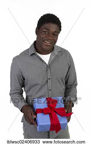 Young black man holding a present View Large Photo Image Stock Image - Young black man holding a present. Fotosearch
