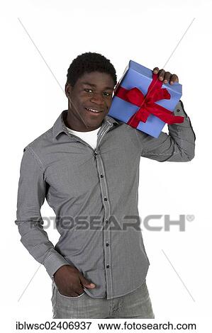 Young black man holding a present View Large Photo Image Stock Photo - Young black man holding a present. Fotosearch