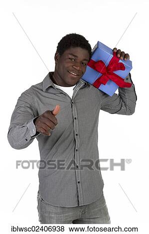 Stock Photo - Young black man holding a present. Fotosearch