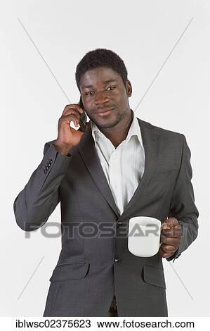 Stock Image - Young black man using a mobile phone. Fotosearch