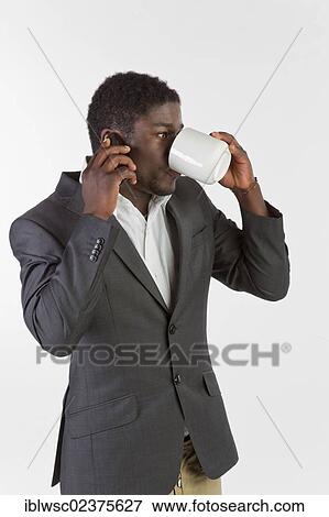 Young black man using a mobile phone and drinking coffee View Large Photo Image Stock Photo - Young black man using a mobile phone and drinking coffee. Fotosearch