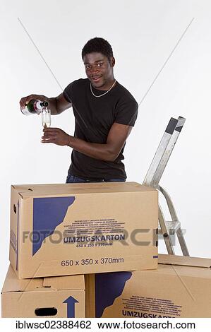 Young black man with moving boxes and a bottle of champagne View Large Photo Image Stock Image - Young black man with moving boxes and a bottle of champagne. Fotosearch