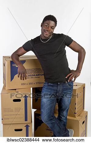 Picture - Young black man with moving boxes. Fotosearch