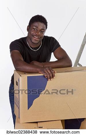 Stock Photo - Young black man with moving boxes. Fotosearch