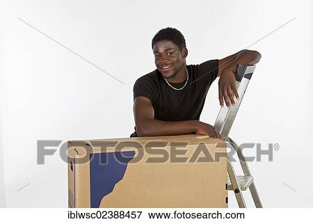 Young black man with moving boxes View Large Photo Image Stock Photo - Young black man with moving boxes. Fotosearch