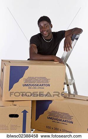 Young black man with moving boxes View Large Photo Image Stock Photo - Young black man with moving boxes. Fotosearch