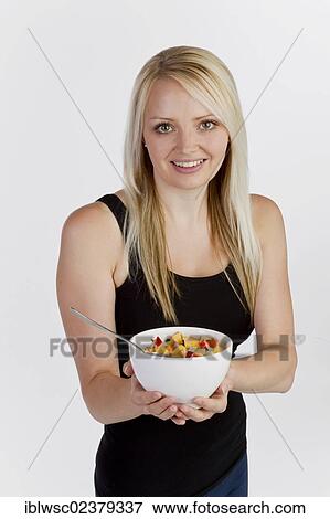 Young blonde woman holding a bowl of muesli View Large Photo Image Stock Photo - Young blonde woman holding a bowl of muesli. Fotosearch