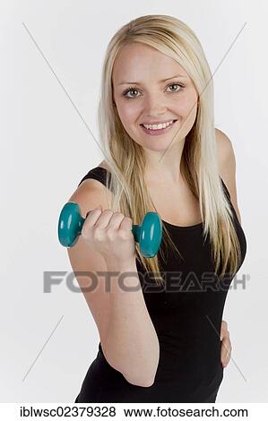 Stock Photo - Young blonde woman holding a dumbbell. Fotosearch