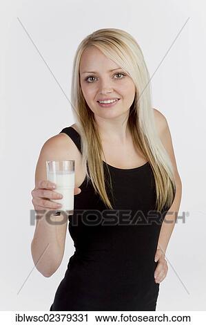 Young blonde woman holding a glass of milk View Large Photo Image Stock Image - Young blonde woman holding a glass of milk. Fotosearch