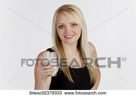 Young blonde woman holding a glass of milk View Large Photo Image Stock Image - Young blonde woman holding a glass of milk. Fotosearch