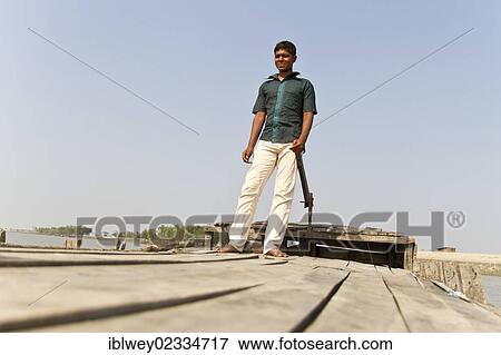 "Young boatman steers his wooden boat, Gabura, Sundabarns, Khulna District, Bangladesh, South Asia, Asia" View Large Photo Image Stock Photo - "Young boatman steers his wooden boat, Gabura, Sundabarns, Khulna District, Bangladesh, South Asia, Asia". Fotosearch