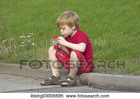 Stock Photography - "Young boy blowing bubbles, Wilhelmsburg, Hamburg, Hamburg, Germany, Europe". Fotosearch