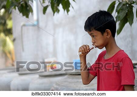 "Young boy brushing his teeth outside a house, Lompong Commune, Bathi District, Takeo Province, Cambodia, Asia" View Large Photo Image Picture - "Young boy brushing his teeth outside a house, Lompong Commune, Bathi District, Takeo Province, Cambodia, Asia". Fotosearch