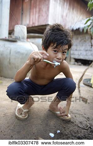 "Young boy brushing his teeth outside a house, Lompong Commune, Bathi District, Takeo Province, Cambodia, Asia" View Large Photo Image Stock Photo - "Young boy brushing his teeth outside a house, Lompong Commune, Bathi District, Takeo Province, Cambodia, Asia". Fotosearch