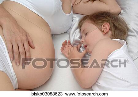 Young boy lying beside the belly of his pregnant mother View Large Photo Image Stock Image - Young boy lying beside the belly of his pregnant mother. Fotosearch