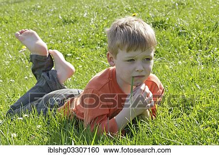 "Young boy lying on grass, Zarrentin, Mecklenburg-Western Pomerania, Germany, Europe" View Large Photo Image Stock Image - "Young boy lying on grass, Zarrentin, Mecklenburg-Western Pomerania, Germany, Europe". Fotosearch