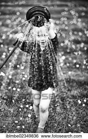 Young boy playing with a watering hose in a garden View Large Photo Image Stock Photograph - Young boy playing with a watering hose in a garden. Fotosearch