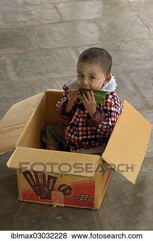 "Young boy put in box to prevent him from running away while his mother is running her souvernir shop, Shwezigon pagoda, Bagan, Mandalay, Myanmar, Burma, Asia" View Large Photo Image Stock Photo - "Young boy put in box to prevent him from running away while his mother is running her souvernir shop, Shwezigon pagoda, Bagan, Mandalay, Myanmar, Burma, Asia". Fotosearch