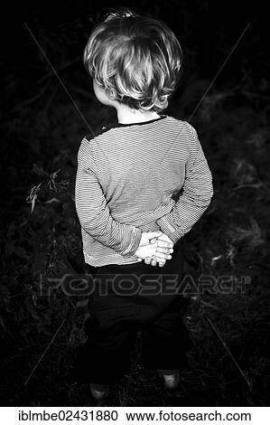 Young boy standing with his hands clasped behind his back View Large Photo Image Stock Image - Young boy standing with his hands clasped behind his back. Fotosearch
