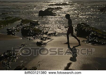 "Young boy walking on the beach in the evening sun, Praia da Amoreira beach, Aljezur, Faro District, Portugal, Europe" View Large Photo Image Stock Image - "Young boy walking on the beach in the evening sun, Praia da Amoreira beach, Aljezur, Faro District, Portugal, Europe". Fotosearch