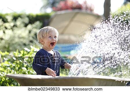 Young boy with his mouth smeared with chocolate playing with a garden hose and laughing View Large Photo Image Stock Image - Young boy with his mouth smeared with chocolate playing with a garden hose and laughing. Fotosearch