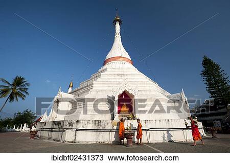 Stock Image - "Young Buddhist monks with offerings in front of a Pagoda or Chedi, Temple complex of Wat Phra That Doi Kong Mu, Mae Hong Son, Northern Thailand, Thailand, Asia". Fotosearch