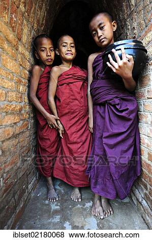 "Young Buddhist novices holding alms bowls in front of the old monastery walls at the Shwezigon Pagoda in Bagan, Myanmar, Burma, Southeast Asia, Asia" View Large Photo Image Stock Photo - "Young Buddhist novices holding alms bowls in front of the old monastery walls at the Shwezigon Pagoda in Bagan, Myanmar, Burma, Southeast Asia, Asia". Fotosearch