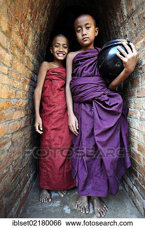 "Young Buddhist novices holding alms bowls in front of the old monastery walls at the Shwezigon Pagoda in Bagan, Myanmar, Burma, Southeast Asia, Asia" View Large Photo Image Stock Photograph - "Young Buddhist novices holding alms bowls in front of the old monastery walls at the Shwezigon Pagoda in Bagan, Myanmar, Burma, Southeast Asia, Asia". Fotosearch