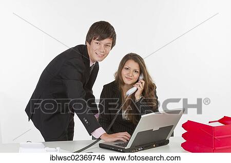 Stock Photograph - Young business people in an office. Fotosearch