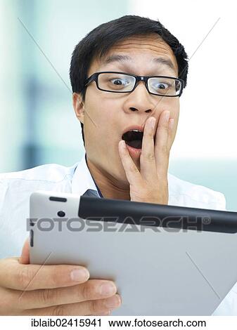 Young businessman, Asian, with glasses, iPad, amazed, surprised, shocked, stressed out View Large Photo Image Stock Image - Young businessman, Asian, with glasses, iPad, amazed, surprised, shocked, stressed out. Fotosearch