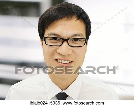 Young businessman, Asian, with glasses, smiling View Large Photo Image Stock Photograph - Young businessman, Asian, with glasses, smiling. Fotosearch
