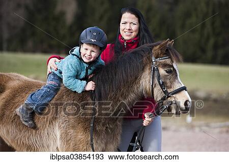 "Young child wearing a riding helmet sitting bareback on a pony, dun, with a bridle, with a riding instructor, Tyrol, Austria, Europe" View Large Photo Image Stock Image - "Young child wearing a riding helmet sitting bareback on a pony, dun, with a bridle, with a riding instructor, Tyrol, Austria, Europe". Fotosearch