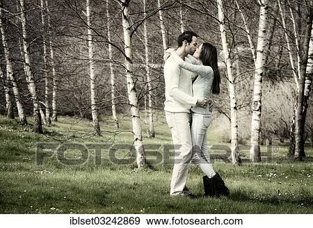 Stock Photo - "Young couple kissing in a birch forest, Austria, Europe". Fotosearch