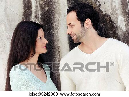 Stock Image - "Young couple looking at each other, smiling, Austria, Europe". Fotosearch