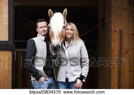 "Young couple standing with a Tyrolean Haflinger in front of a stall, North Tyrol, Austria, Europe" View Large Photo Image Stock Image - "Young couple standing with a Tyrolean Haflinger in front of a stall, North Tyrol, Austria, Europe". Fotosearch