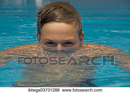 Young emerges from the water in a swimming pool View Large Photo Image Stock Photo - Young emerges from the water in a swimming pool. Fotosearch