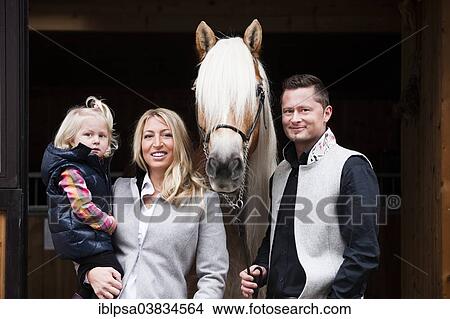 "Young family standing with a Tyrolean Haflinger in front of a stall, North Tyrol, Austria, Europe" View Large Photo Image Picture - "Young family standing with a Tyrolean Haflinger in front of a stall, North Tyrol, Austria, Europe". Fotosearch