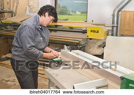 Picture - "Young farmer repairing a hay rake, sharpening teeth on the belt sander, Sprenger family farm, Schwaz District, Tyrol, Austria Family". Fotosearch