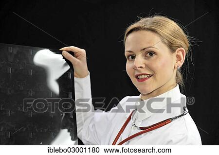 Stock Image - "Young female doctor holding an X-ray, Schwabisch Gmund, Ostalbkreis, Baden-Wurttemberg, Germany, Europe". Fotosearch