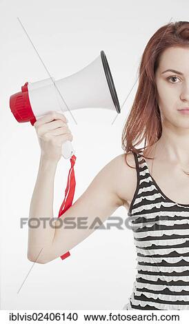 Young female holding a megaphone by her ear View Large Photo Image Stock Image - Young female holding a megaphone by her ear. Fotosearch