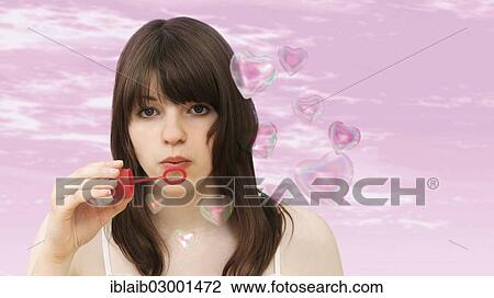Young girl blowing heart-shaped soap-bubbles View Large Photo Image Stock Image - Young girl blowing heart-shaped soap-bubbles. Fotosearch