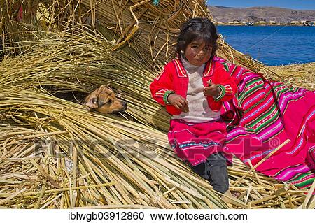 "Young girl of the Uro Indians, about 5 years old, wearing traditional dress, sitting next to a dog on reed bundles, floating islands made of totora reeds, Lake Titicaca, southern Peru, Peru, South America" View Large Photo Image Stock Image - "Young girl of the Uro Indians, about 5 years old, wearing traditional dress, sitting next to a dog on reed bundles, floating islands made of totora reeds, Lake Titicaca, southern Peru, Peru, South America". Fotosearch