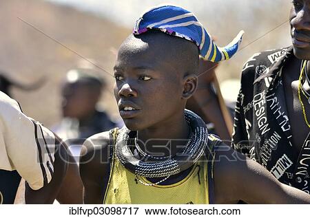 Stock Photo - "Young Himba man wearing a traditional headdress, cap in the form of a cattle horn, Omohanja, Kaokoland, Kunene, Namibia, Africa". Fotosearch