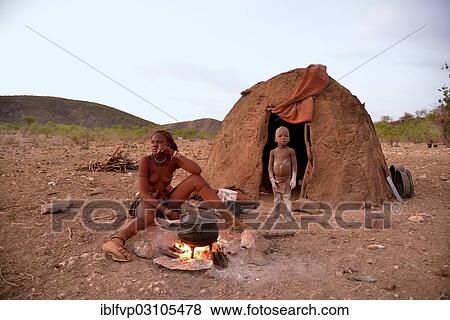 "Young Himba woman cooking food on a campfire outside her hut, Ombombo, Kaokoland, Kunene, Namibia, Africa" View Large Photo Image Stock Photo - "Young Himba woman cooking food on a campfire outside her hut, Ombombo, Kaokoland, Kunene, Namibia, Africa". Fotosearch
