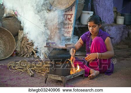 "Young Indian woman squating on the ground and preparing a meal on a hotplate, Jodhpur, Rajasthan, India, Asia" View Large Photo Image Stock Photograph - "Young Indian woman squating on the ground and preparing a meal on a hotplate, Jodhpur, Rajasthan, India, Asia". Fotosearch
