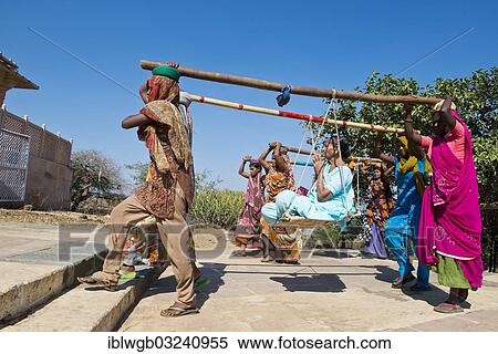 "Young Indian women wearing traditional saris carrying long bamboo poles on their heads with a seat for pilgrims climbing the steps to the temple complex, Tempelberg Shatrunjaya, Palitana, Gujarat, India, Asia" View Large Photo Image Stock Photography - "Young Indian women wearing traditional saris carrying long bamboo poles on their heads with a seat for pilgrims climbing the steps to the temple complex, Tempelberg Shatrunjaya, Palitana, Gujarat, India, Asia". Fotosearch