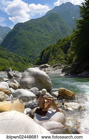 "Young lady sunbathing by rocky alpine foothills stream in the remote valley of Val Verzasca, near Lavertezzo, Ticino, Alps, Switzerland, Europe" View Large Photo Image Stock Image - "Young lady sunbathing by rocky alpine foothills stream in the remote valley of Val Verzasca, near Lavertezzo, Ticino, Alps, Switzerland, Europe". Fotosearch