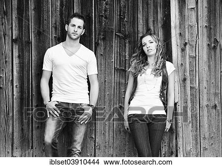 Young man and a young woman leaning against wooden wall View Large Photo Image Picture - Young man and a young woman leaning against wooden wall. Fotosearch