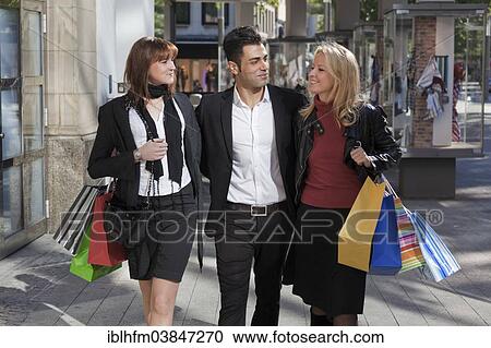"Young man and two young women, arm in arm with shopping bags, downtown, Hanover, Lower Saxony, Germany, Europe" View Large Photo Image Stock Image - "Young man and two young women, arm in arm with shopping bags, downtown, Hanover, Lower Saxony, Germany, Europe". Fotosearch